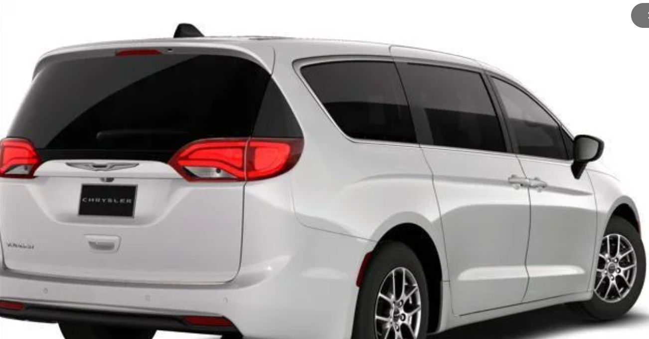 A white Chrysler Voyager minivan with a sleek rear design and polished alloy wheels